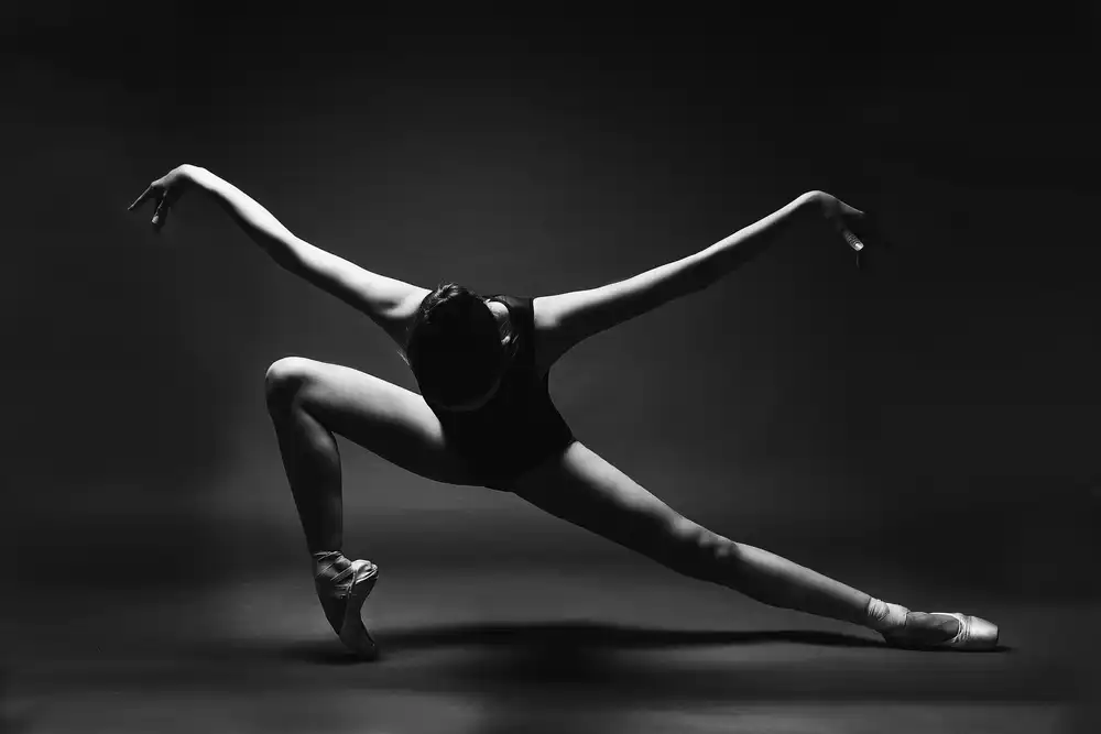 Alexandr: impennata. Una ballerina con le scarpe da punta in un affondo con le braccia tese come ali
