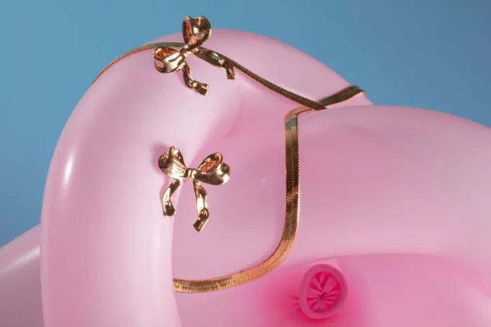 Ramiro, Julia: Bandschleife-Ohrring und Halskette auf rosa Ballon