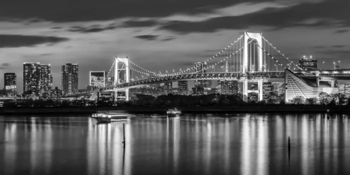 Viola, Melanie: Bezaubernde Rainbow Bridge und Tokioter Skyline bei Sonnenuntergang - monochromes Panorama